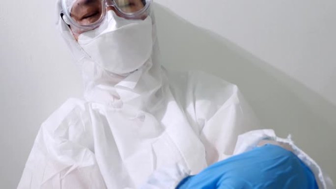 穿着PPE套装的疲惫的亚洲医生坐在地板上睡觉，过度劳累的医生慢动作拍摄