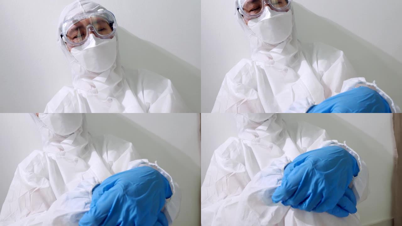 穿着PPE套装的疲惫的亚洲医生坐在地板上睡觉，过度劳累的医生慢动作拍摄