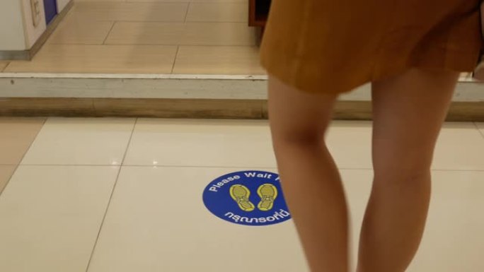 POV，女人脚走在购物中心，新型冠状病毒肺炎商务标牌在地板上，新的正常概念