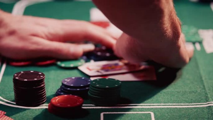 赌徒从扑克桌中间抓住所有扑克筹码的特写镜头赚取利润