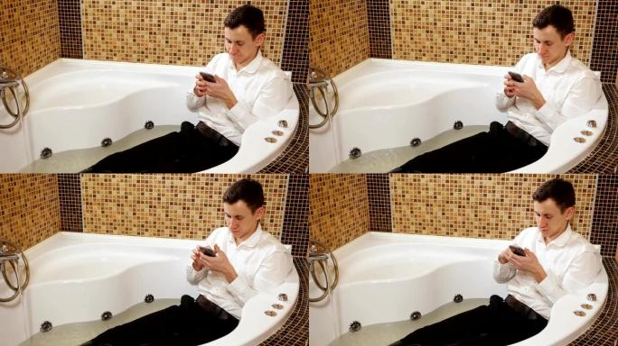 穿着裤子和带有电话的衬衫的男人躺在水浴中