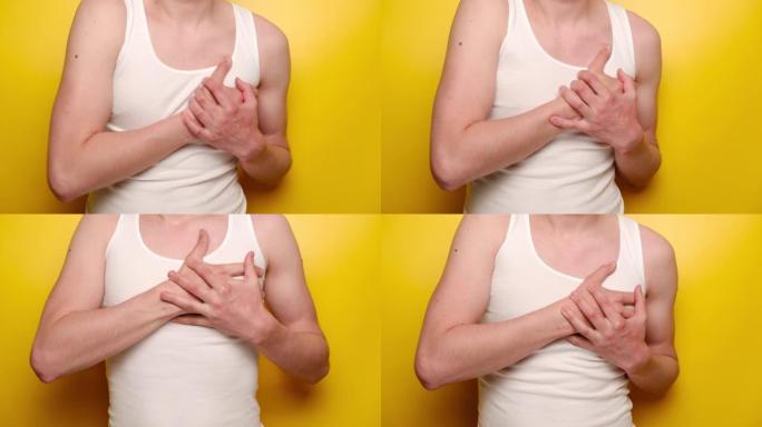 年轻人感觉疼痛疼痛的特写触摸胸部有心脏病发作，孤立在黄色背景上。无法识别的家伙患有心痛，梗塞或男性心