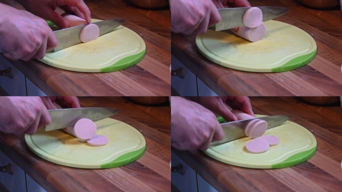 用锋利的刀慢动作将香肠切成小块放在厨房架子上的厨房板上