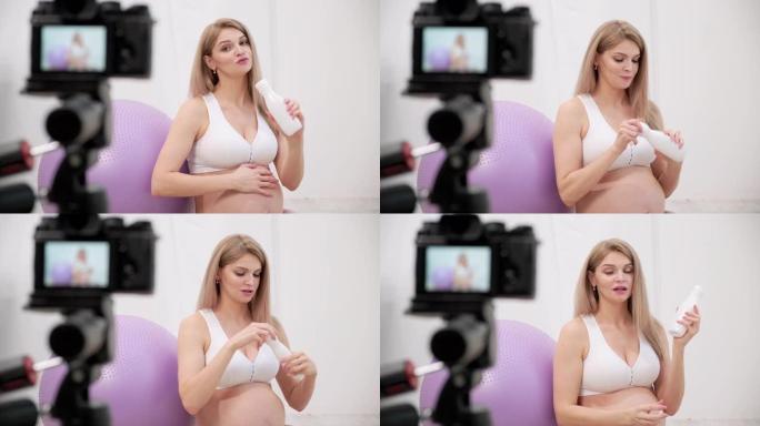 一位运动的孕妇年轻博客作者谈论球操。