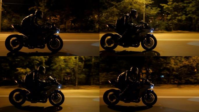 男子在晚间城市街快速骑现代黑色运动摩托车。摩托车手在夜间空旷的道路上骑摩托车。开着前灯驾驶自行车的人