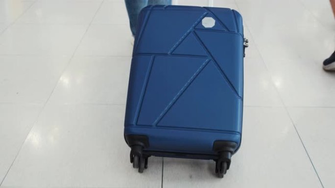 低角度女人在机场出发时带着手提箱行走