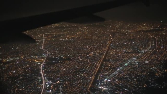 巴西里约热内卢，拉丁美洲的城市景观夜空，房屋和道路被照亮，飞机机翼被拍摄