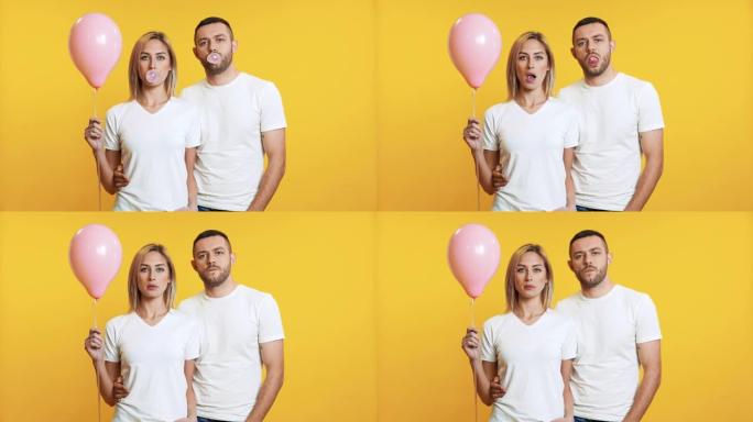 年轻夫妇用口香糖吹泡泡，在黄色背景上拿着粉红色的气球