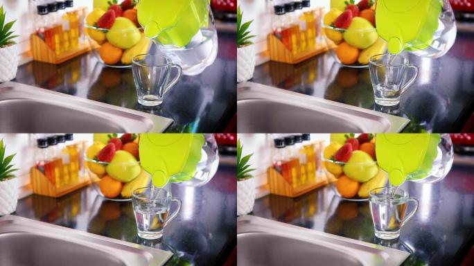 将过滤后的水从厨房的水罐倒入玻璃杯中
