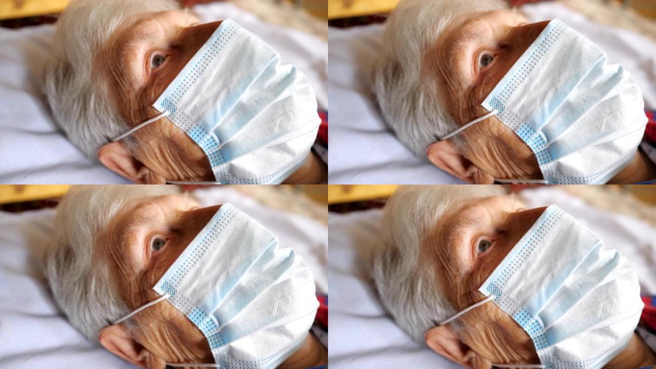 戴着病毒防护面具的老妇人的特写脸。生病的女士带着悲伤的视力和医用口罩躺在医院的床上。健康或安全生命的