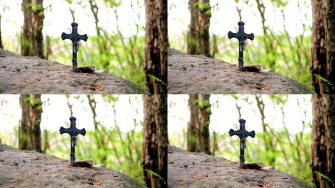 特写，金属十字架，基督的耶稣受难像，坐落在石头里，在森林里，在神圣的纪念碑里，在春天的森林里
