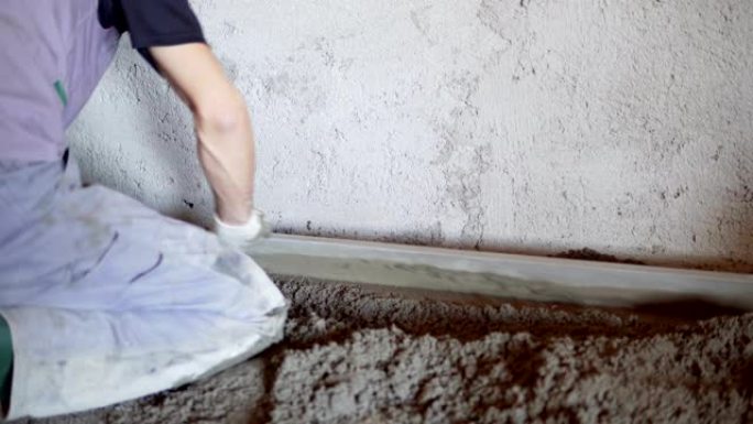 一名建筑工人正在浇筑水泥和混凝土。工头在道路上新浇筑混凝土