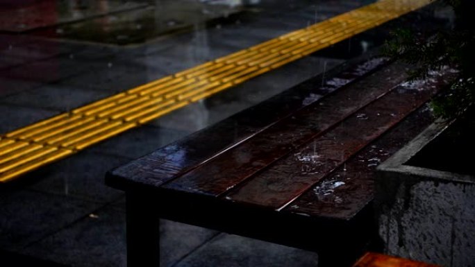 热带雨水在城市的戏剧性木凳上滴落