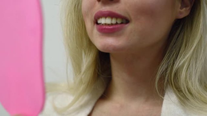 牙科用镜子检查牙齿的年轻女性病人。牙医诊所的女性。