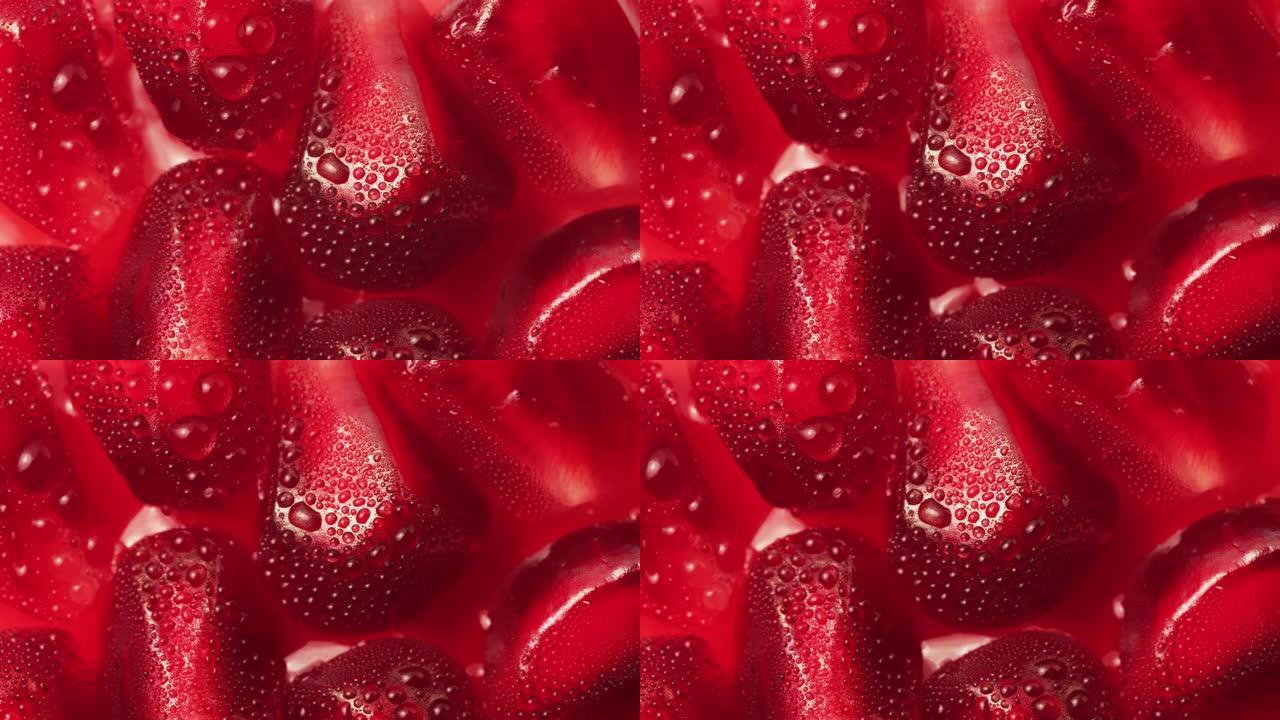 明亮的新鲜红色石榴水果种子的宏观镜头，果汁在白色背景上的种子之间移动。健康，充满活力的红色和抗氧化水