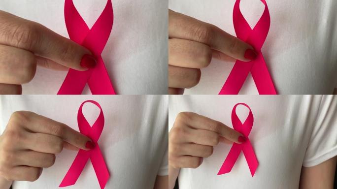 手里拿着粉红丝带的女孩。抗击乳腺癌的概念。