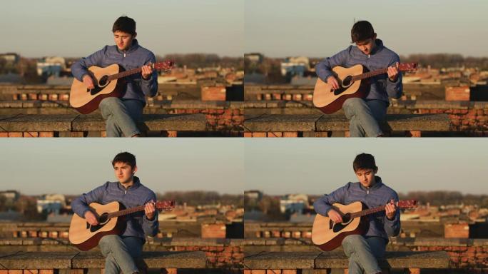夕阳下的年轻人在房子的屋顶上弹吉他。自由概念