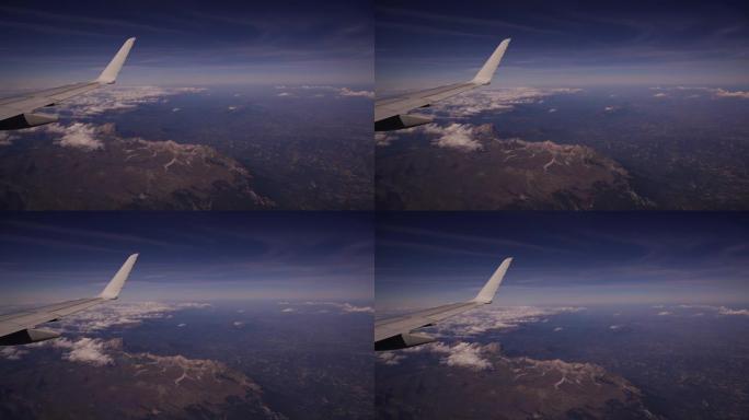从飞机上可以看到意大利的格兰萨索和蒙蒂德拉拉加国家公园。蓝天上美丽的白堆云的鸟瞰图。舷窗的飞机机翼。