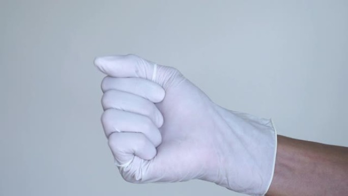 男子戴上乳胶手套，以保护白色背景的新型冠状病毒肺炎病毒。