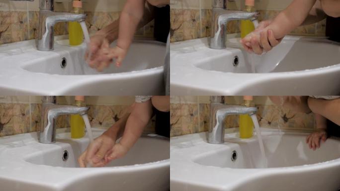 母亲在水龙头保护下用水清洗婴儿的手，以防感染病毒