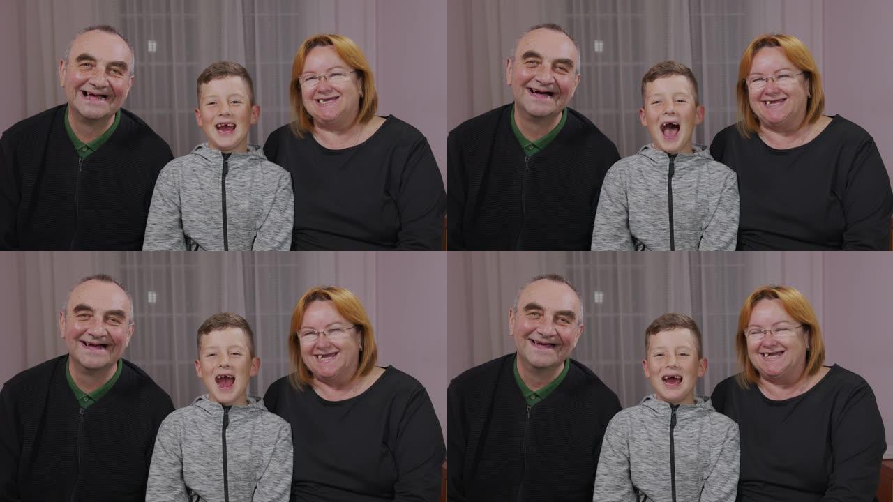 快乐无牙的爷爷、奶奶和孙子一起在镜头前大笑。特写。