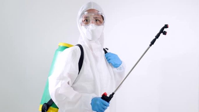 慢动作亚洲病毒学科学家穿着PPE套装并使用化学设备喷洒以清除细菌。