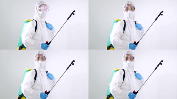 慢动作亚洲病毒学科学家穿着PPE套装并使用化学设备喷洒以清除细菌。