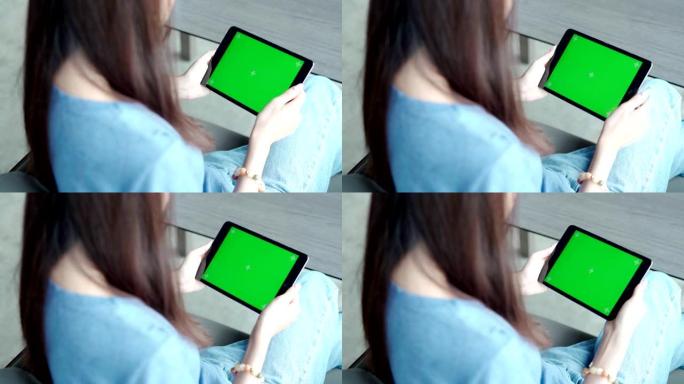 女孩拿着平板电脑绿屏边看东西