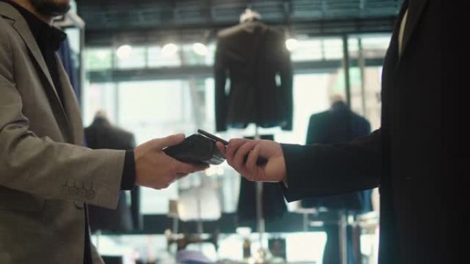 男子在男装商店用智能手机付款