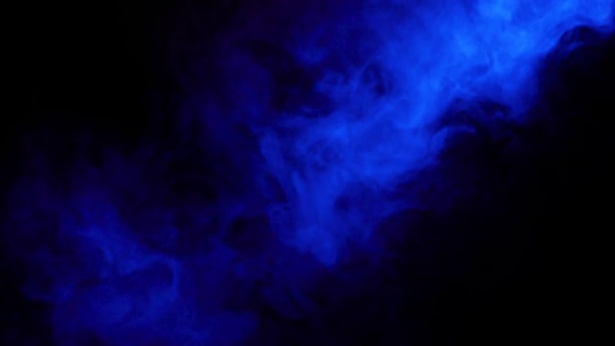 黑色背景上的蓝色烟雾。彩色烟雾在黑色背景下缓慢漂浮在空间中。