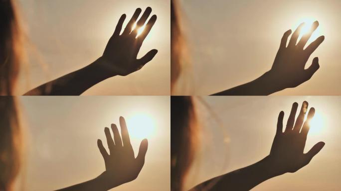 女孩触摸夕阳的手指。浪漫概念
