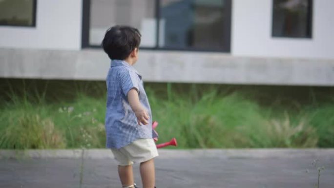 亚洲男婴在花园之家跑步