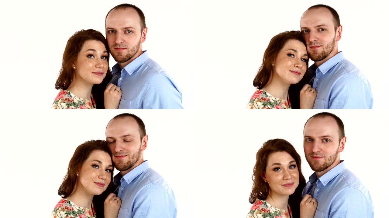 幸福的夫妇拥抱和看白色背景上的相机