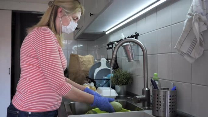 戴防护面罩和手套洗菜的女人