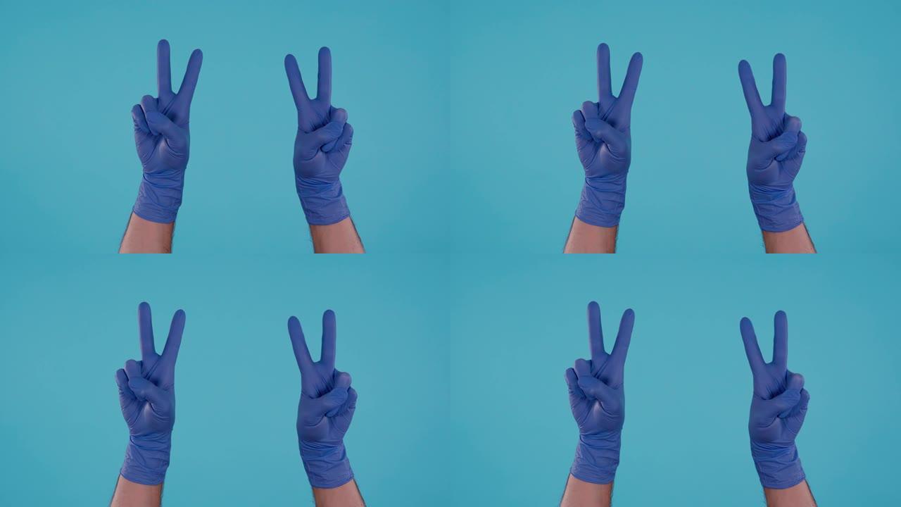 蓝色背景上显示和平标志的蓝色手术乳胶手套的男性手