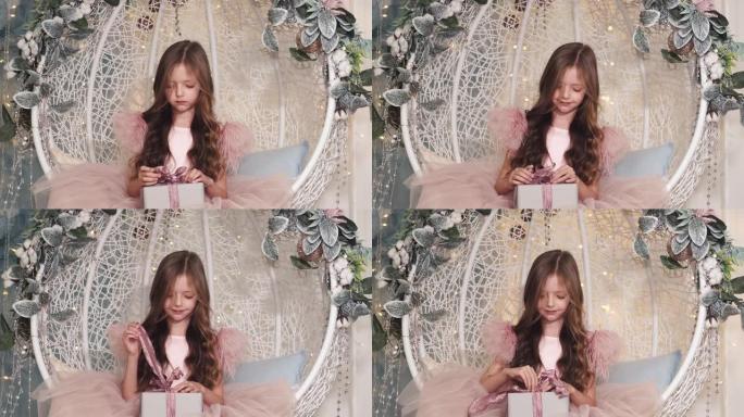 小女孩坐在装饰好的工作室里拿着礼物