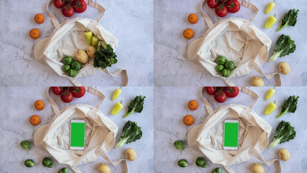 杂货素食产品聚集在可重复使用的袋子上，手机绿屏界面采用平铺设计。新鲜蔬菜网上购物和电子商务。停止运动