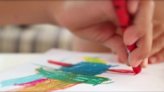红色蜡笔笔颜色在纸上的儿童手绘。儿童创造性地绘画