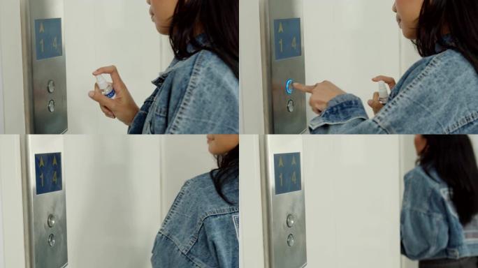 妇女使用电梯按钮上的卫生消毒剂喷雾清洁唾液滴。