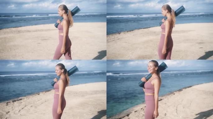 背面视图，穿着运动服和体操垫的年轻女子去海滩