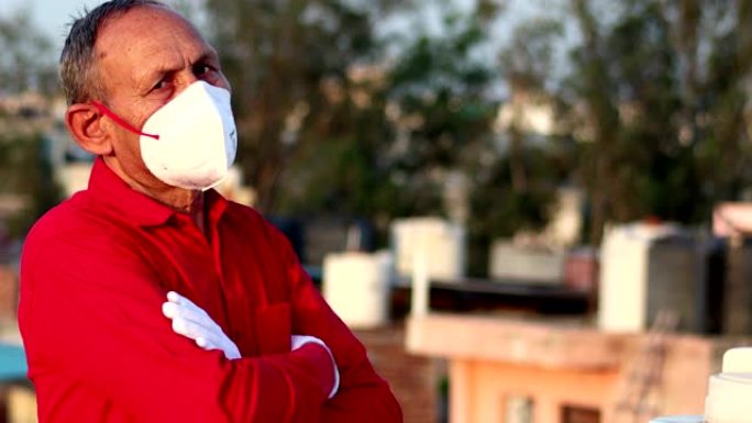 高级男子用防污口罩遮住脸，防止新型冠状病毒肺炎和使用手机