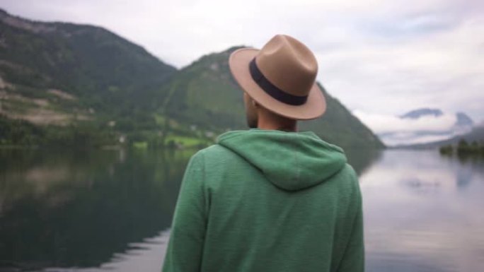 男子站在雾中看着山湖的景色