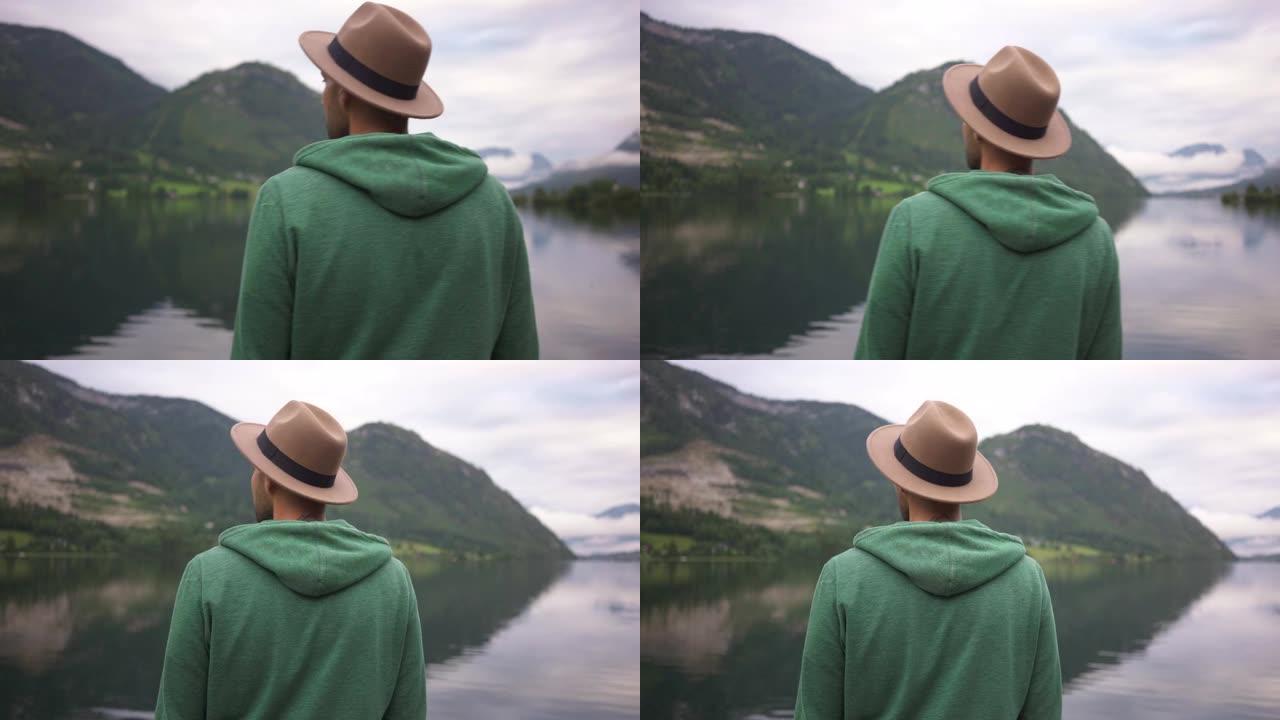 男子站在雾中看着山湖的景色