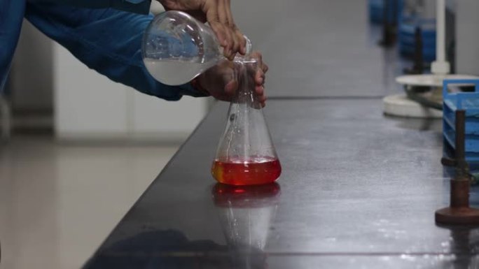 在化学实验室中，从圆锥形烧瓶中添加白色化学物质后，圆锥形烧瓶中黄色化学物质的颜色会发生变化。