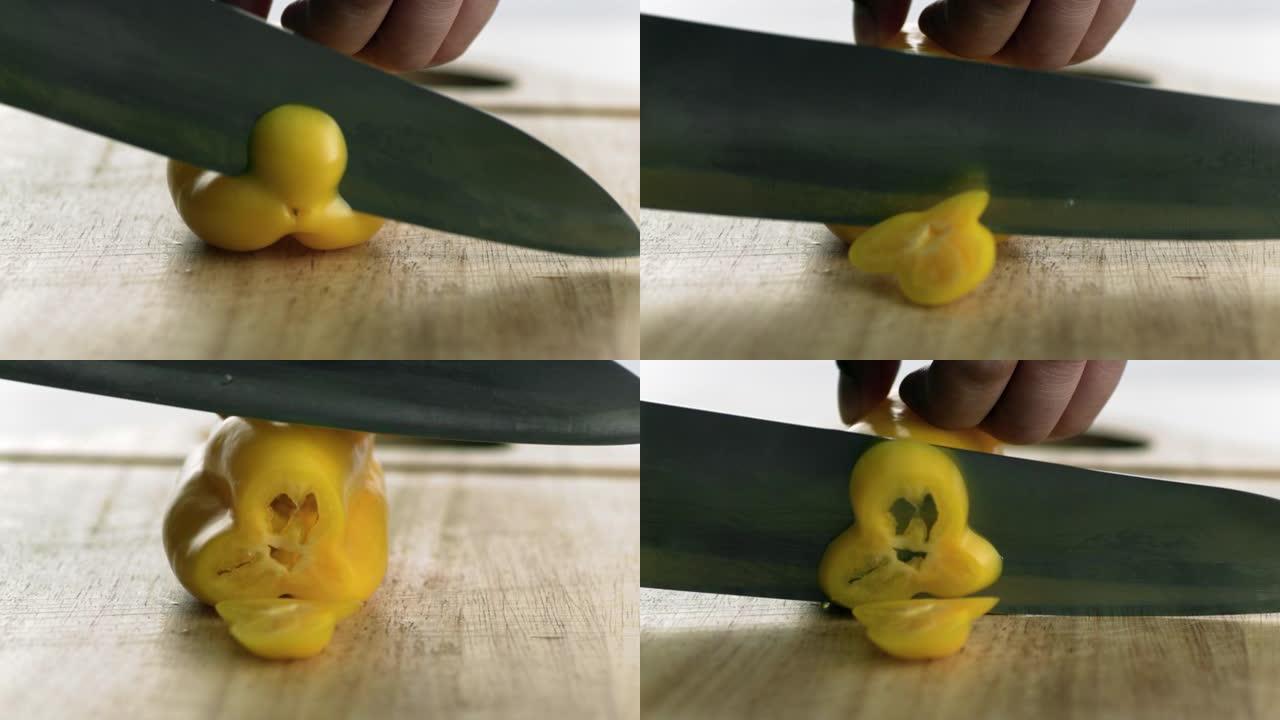这是一刀切穿黄色辣椒 (黄色甜椒) 的高速 (慢动作) 镜头。在幻影相机上高速拍摄。(厨房里的时尚食