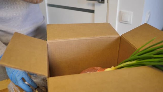志愿者戴着手套，带着食物捐款箱放蔬菜帮助他人。装有食品的捐款箱。全高清视频