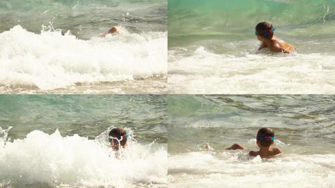 海浪的海浪覆盖了一个穿着泳衣和游泳镜的小男孩