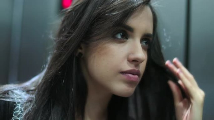 年轻的西班牙裔拉丁女孩在镜子里微笑着整理头发