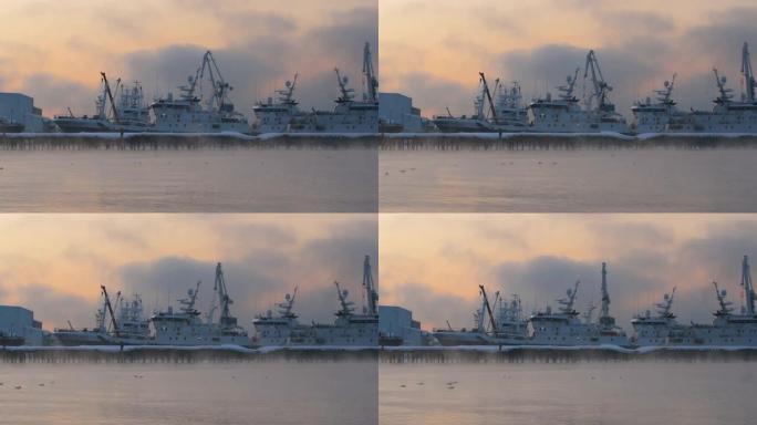 清晨，在雾中日出时，船只在港口