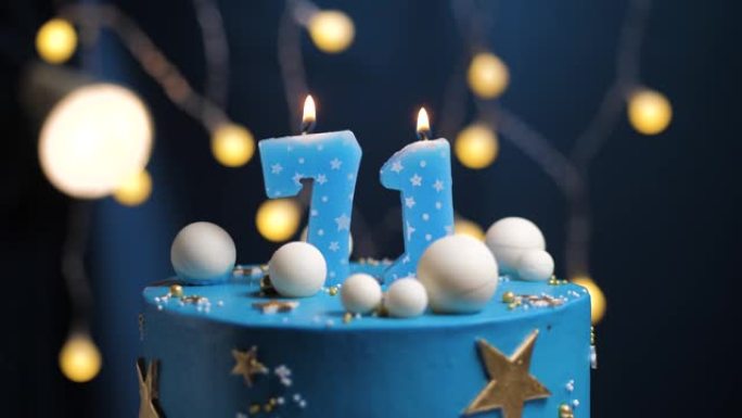 生日蛋糕编号71星星天空和月亮概念，蓝色蜡烛被打火机点燃，然后吹灭。如果需要，请在屏幕右侧复制空间。